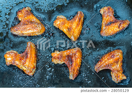 Caramelized chicken wings on the baking tray 28050129