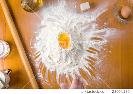 Broken egg on flour with baking tools 28051183