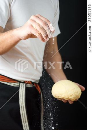 Male baker holding dough and flour 28051186