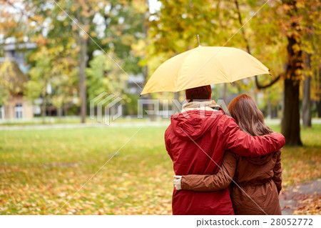 happy couple with umbrella walking in autumn park 28052772