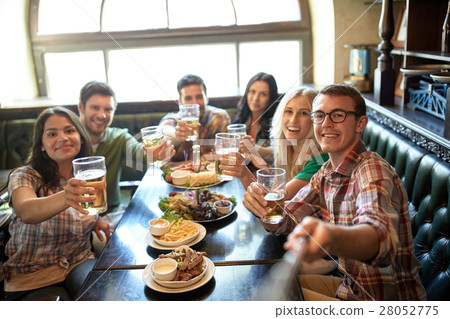 happy friends with selfie stick at bar or pub happy friends with selfie stick at bar or pub 28052775