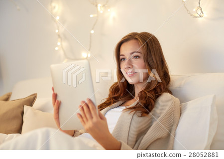 happy young woman with tablet pc in bed at home 28052881