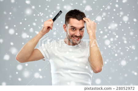 happy man brushing hair with comb over snow happy man brushing hair with comb over snow 28052972