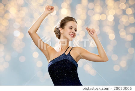 happy woman dancing with raised hands over lights 28053006