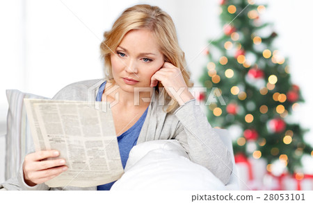 woman reading newspaper at christmas woman reading newspaper at christmas 28053101