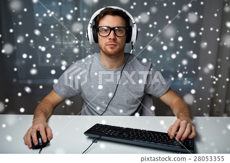 man in headset playing computer video game at home man in headset playing computer video game at home 28053355