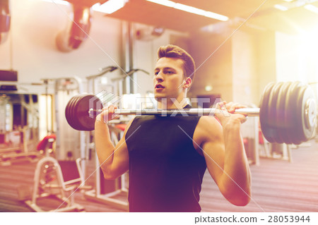 young man flexing muscles with barbell in gym 28053944