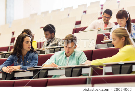 group of students with notebooks in lecture hall 28054063
