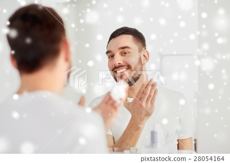 happy man applying shaving foam at bathroom mirror happy man applying shaving foam at bathroom mirror 28054164