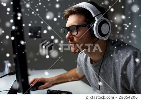 man in headset playing computer video game at home man in headset playing computer video game at home 28054206