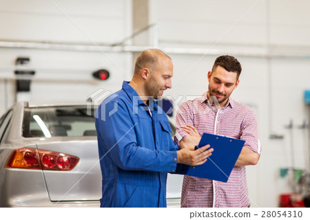 auto mechanic with clipboard and man at car shop 28054310