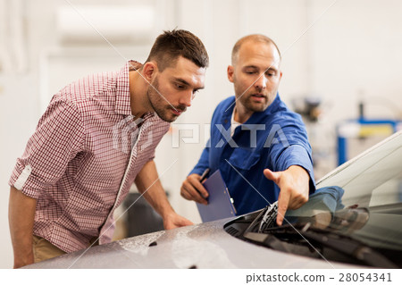 auto mechanic with clipboard and man at car shop 28054341