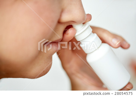 close up of sick woman using nasal spray 28054575