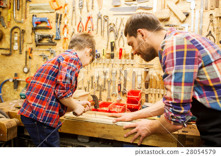 father and son with hammer working at workshop father and son with hammer working at workshop 28054579