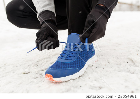 close up of man tying shoe lace in winter outdoors close up of man tying shoe lace in winter outdoors 28054961