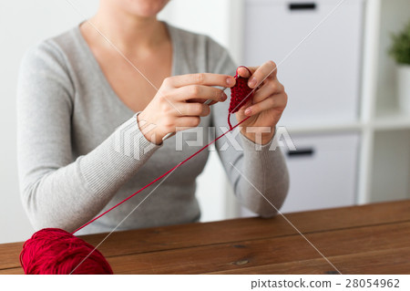 woman knitting with crochet hook and red yarn woman knitting with crochet hook and red yarn 28054962