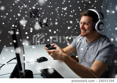 man in headset playing computer video game at home man in headset playing computer video game at home 28055194