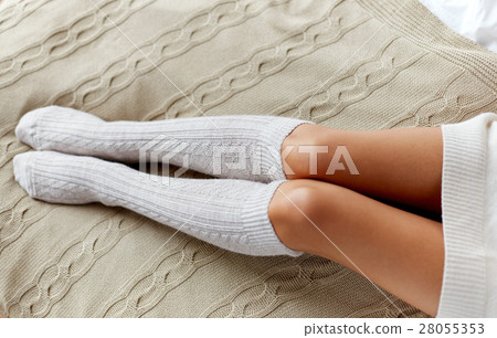 close up of woman legs in winter knee socks in bed close up of woman legs in winter knee socks in bed 28055353