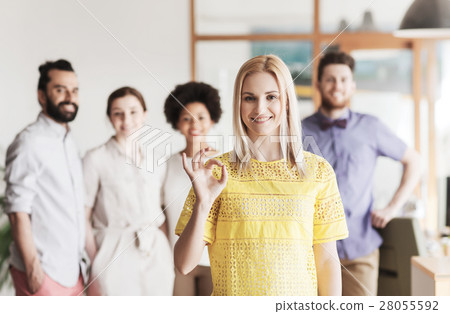 happy woman showing ok over creative office team 28055592