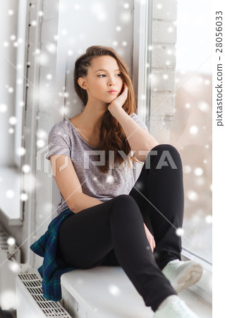 sad pretty teenage girl looking through window sad pretty teenage girl looking through window 28056033