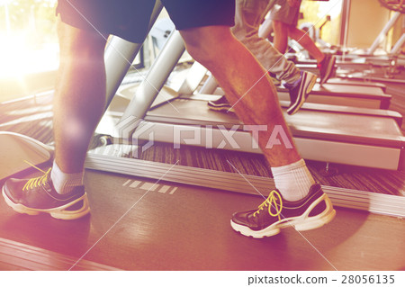 close up of men legs walking on treadmills in gym close up of men legs walking on treadmills in gym 28056135