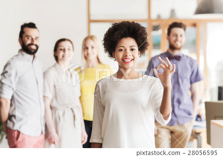 happy woman showing ok over creative office team 28056595