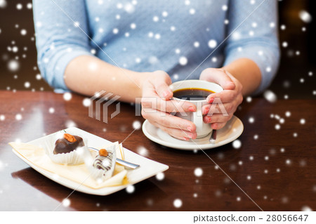 close up of woman holding coffee cup and dessert close up of woman holding coffee cup and dessert 28056647