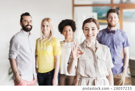 happy woman showing ok over creative office team 28057233