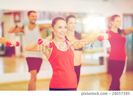 group of smiling people working out with dumbbells group of smiling people working out with dumbbells 28057395