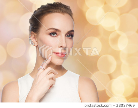 smiling woman in white dress with diamond jewelry 28057469