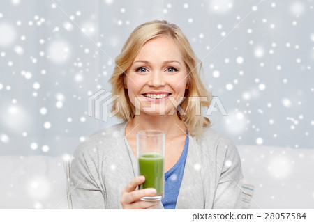 happy woman drinking green juice or shake at home happy woman drinking green juice or shake at home 28057584