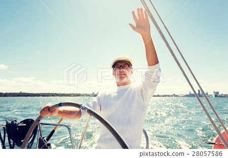 senior man at helm on boat or yacht sailing in sea senior man at helm on boat or yacht sailing in sea 28057586