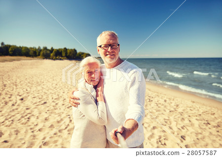 seniors taking picture with selfie stick on beach seniors taking picture with selfie stick on beach 28057587