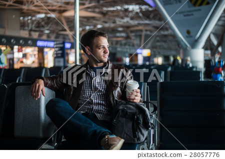 Young attractive man at the airport with his bag Young attractive man at the airport with his bag 28057776