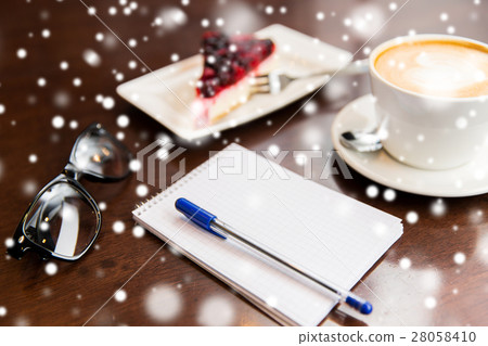 close up of notebook with pen, coffee cup and cake close up of notebook with pen, coffee cup and cake 28058410