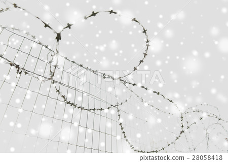 barb wire fence over gray sky and snow barb wire fence over gray sky and snow 28058418