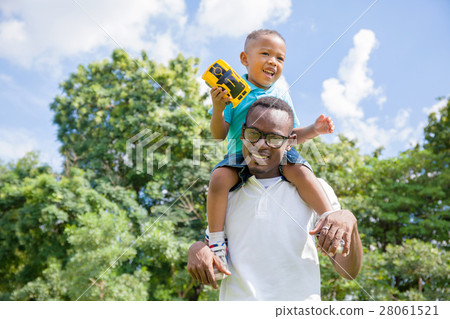 African American father and son piggyback in park 28061521