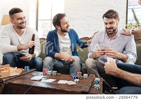 Delighted bearded man looking at his cards 28064779