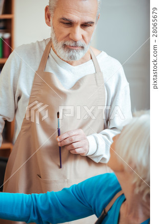 Concentrated artist giving advice to his female 28065679