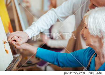 Artist helping his elderly colleague in painting Artist helping his elderly colleague in painting 28065681