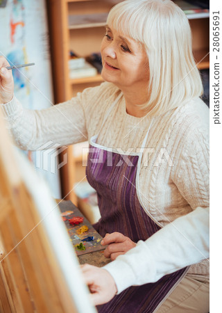Delighted woman painting on a canvas Delighted woman painting on a canvas 28065691