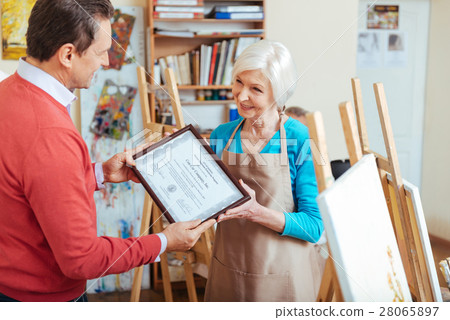 Overjoyed man giving artists diploma to woman Overjoyed man giving artists diploma to woman 28065897