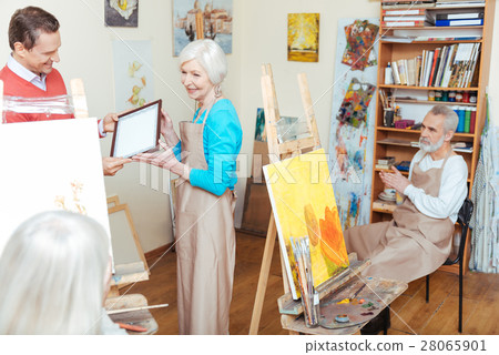 Young man giving artists diploma to woman Young man giving artists diploma to woman 28065901
