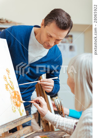 Serious man teaching elderly woman in painting Serious man teaching elderly woman in painting 28065922