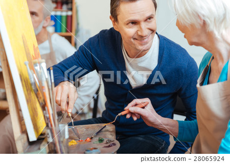 Friendly artist helping elderly woman in painting Friendly artist helping elderly woman in painting 28065924