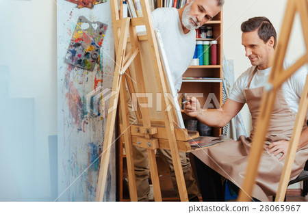 Elderly man painting with his young colleague. Elderly man painting with his young colleague. 28065967