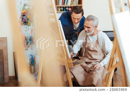 Handsome artist helping elderly man in painting 28065969