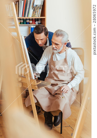 Talented artist helping elderly man in painting 28065972