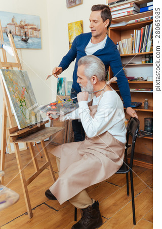 Ambitious artist helping elderly man in painting Ambitious artist helping elderly man in painting 28065985