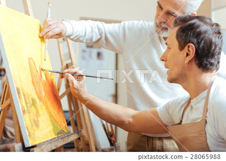 Elderly artist painting with his young colleague. Elderly artist painting with his young colleague. 28065988